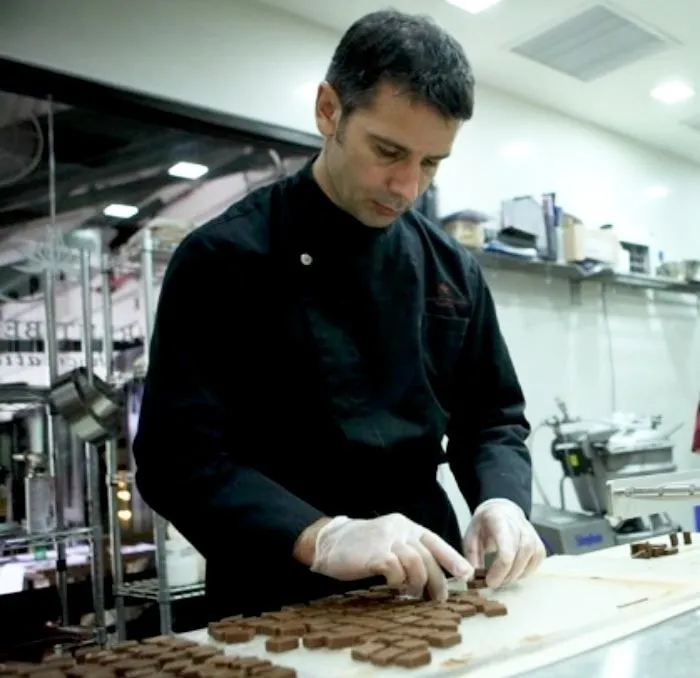 Laurent Bernard in chef's whites arranging chocolates by hand in his kitchen