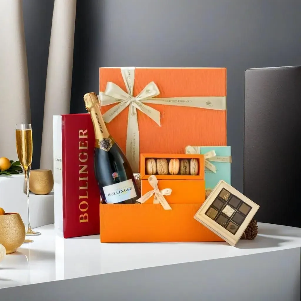 Orange Laurent Bernard hamper with a bottle of Bollinger, a box of macarons and a chocolate box