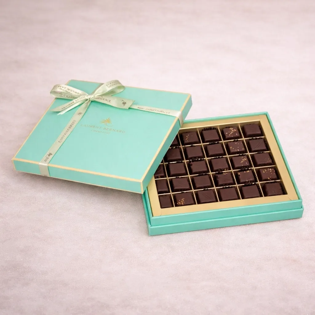 Luxury artisan chocolate gift box by Laurent Bernard Chocolatier, featuring an elegant turquoise box with gold ribbon .